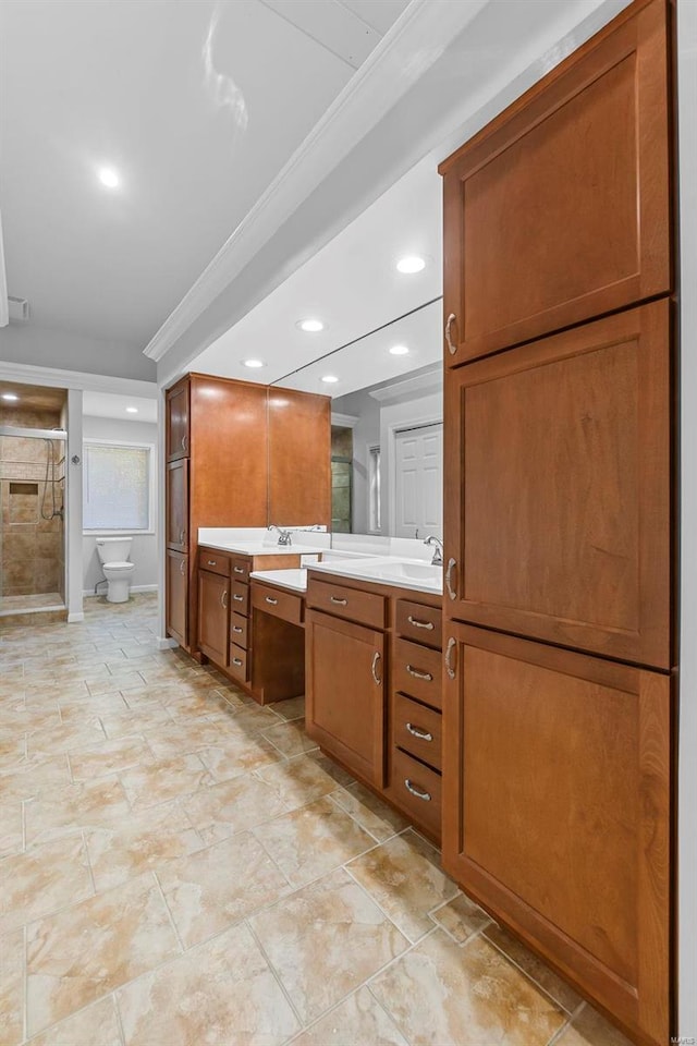 bathroom with vanity, ornamental molding, toilet, and walk in shower