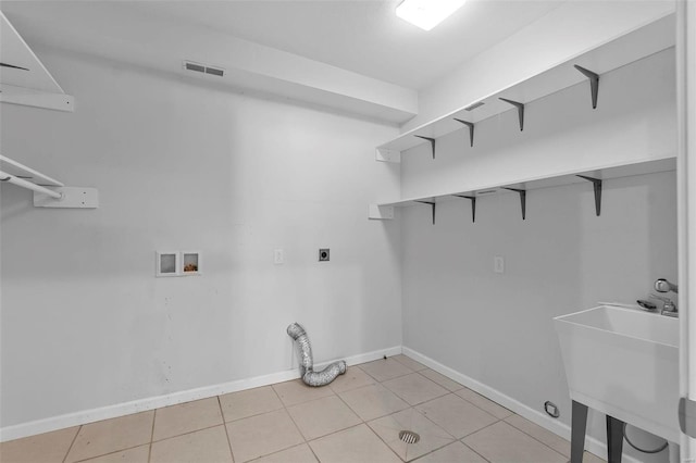 laundry room featuring light tile patterned flooring, sink, hookup for a washing machine, and electric dryer hookup