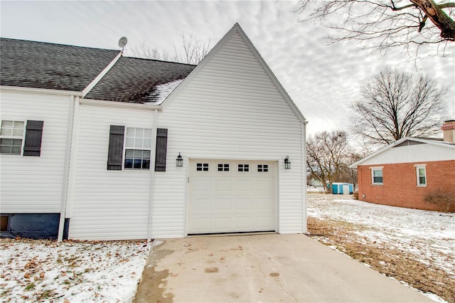 view of snow covered exterior featuring a garage