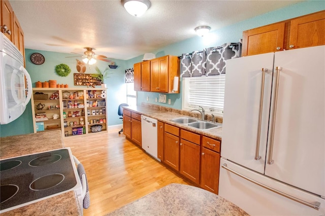 kitchen with sink, white appliances, ceiling fan, light hardwood / wood-style floors, and a textured ceiling