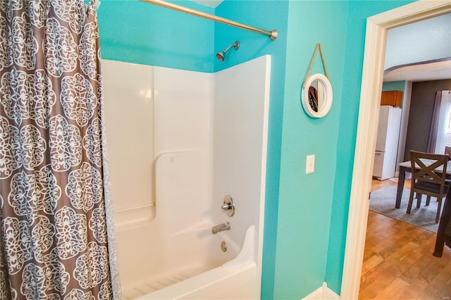 bathroom featuring hardwood / wood-style flooring and shower / tub combo with curtain