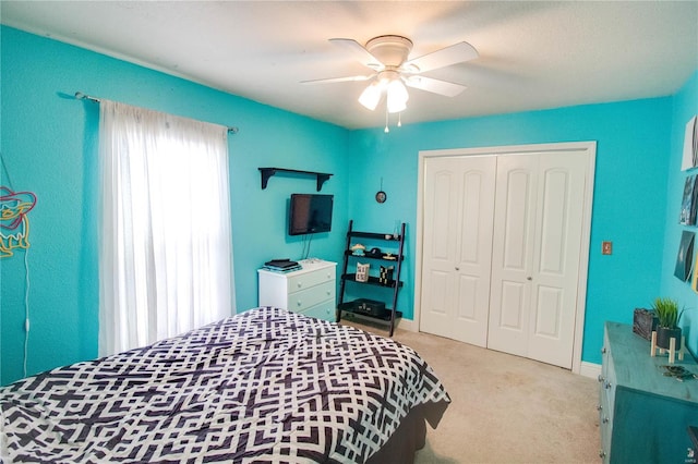 carpeted bedroom with ceiling fan and a closet