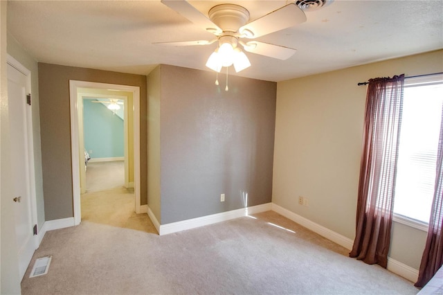 carpeted empty room featuring ceiling fan