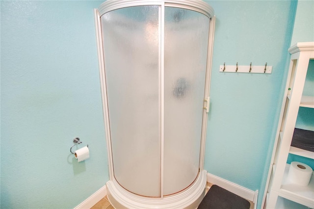 bathroom featuring an enclosed shower and tile patterned floors