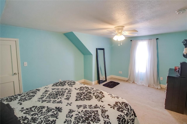 carpeted bedroom featuring ceiling fan and a textured ceiling