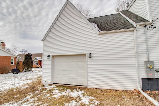 view of snowy exterior featuring a garage