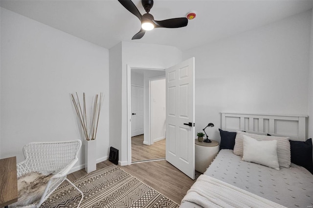 bedroom featuring wood finished floors, a ceiling fan, and baseboards