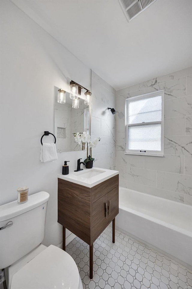 bathroom featuring shower / bathtub combination, toilet, visible vents, vanity, and tile patterned floors