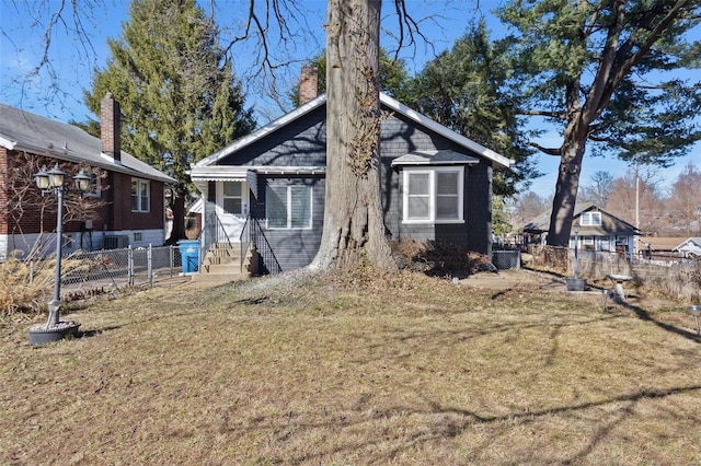 back of property featuring fence and a lawn