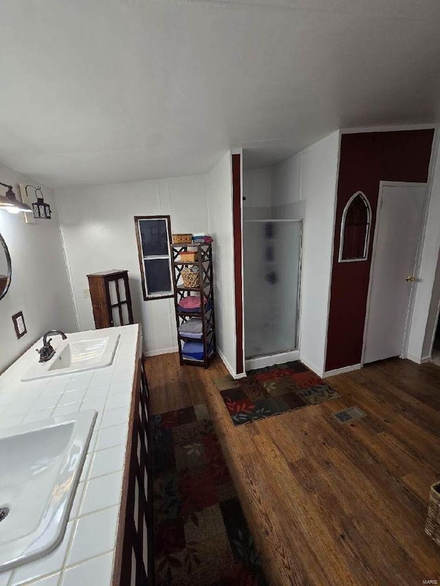 interior space with sink, tile counters, and dark hardwood / wood-style floors