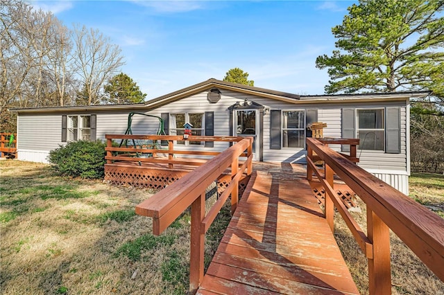 rear view of house with a lawn and a deck