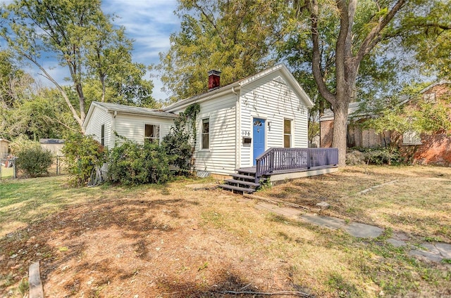 view of front facade with a deck and a front lawn