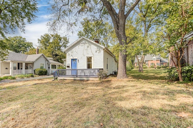 rear view of house featuring a yard and a deck