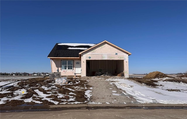 unfinished property featuring a garage and stucco siding