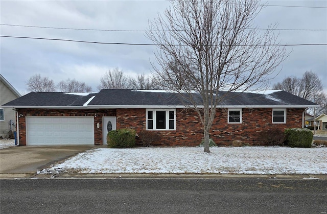 ranch-style home featuring driveway, brick siding, roof with shingles, and an attached garage