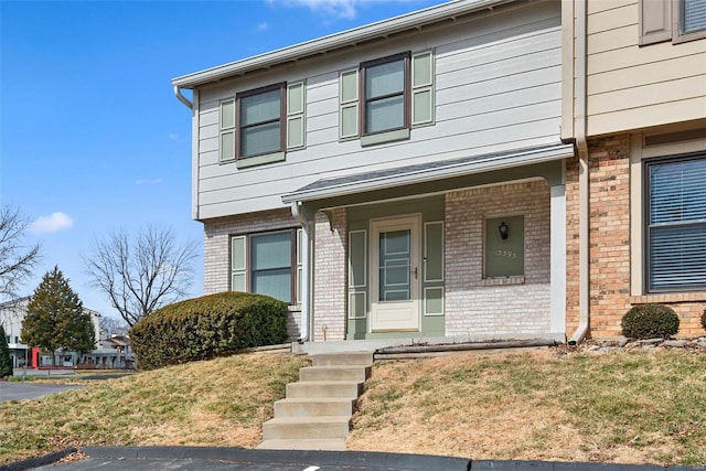 view of front of house with a front yard and brick siding