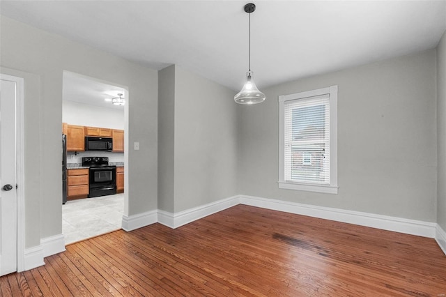 unfurnished dining area featuring light wood-type flooring