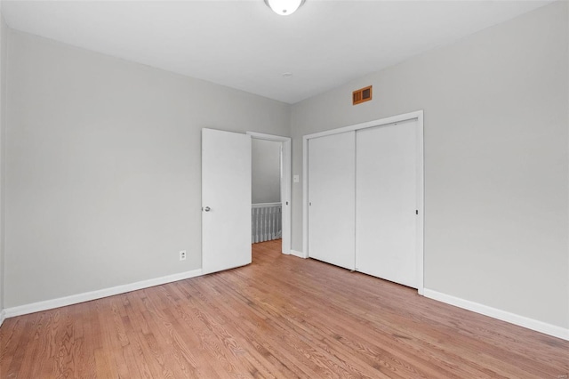 unfurnished bedroom featuring light hardwood / wood-style floors and a closet