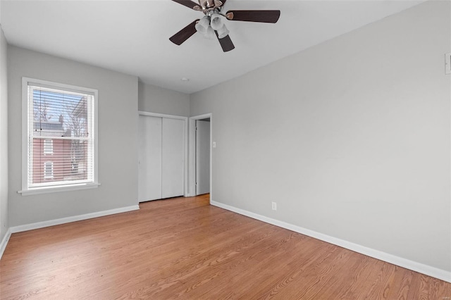 unfurnished bedroom featuring ceiling fan, light hardwood / wood-style floors, and a closet