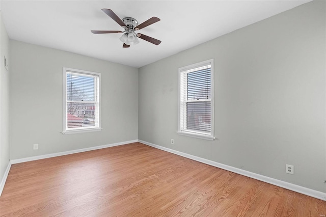 empty room featuring ceiling fan, a healthy amount of sunlight, and light hardwood / wood-style floors