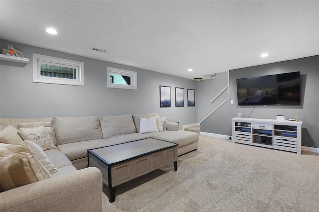 carpeted living area with recessed lighting, visible vents, a textured ceiling, and baseboards