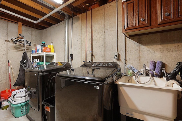 laundry room with cabinet space, washer and clothes dryer, and a sink