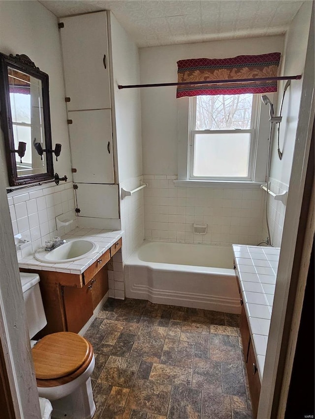 full bathroom featuring tasteful backsplash, vanity, toilet, and washtub / shower combination
