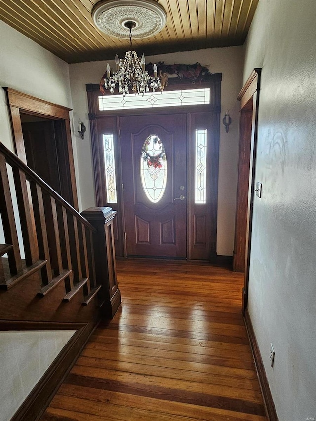 foyer with dark hardwood / wood-style flooring, a chandelier, and wood ceiling