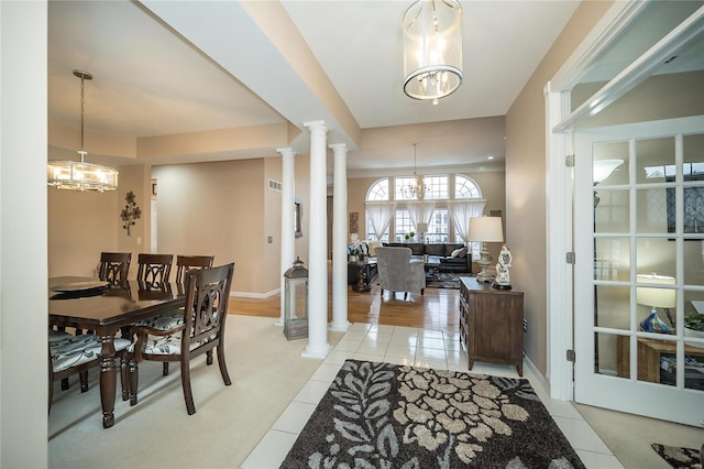 interior space with light tile patterned floors, decorative columns, baseboards, and a notable chandelier