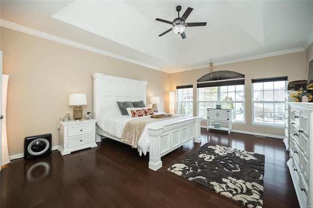 bedroom featuring dark wood-style floors, a raised ceiling, crown molding, and baseboards