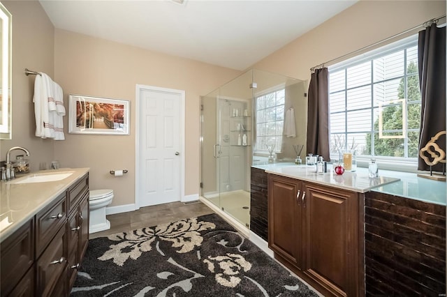 full bathroom featuring toilet, a stall shower, baseboards, and vanity