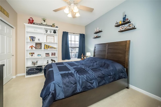 bedroom with a closet, baseboards, a ceiling fan, and light colored carpet