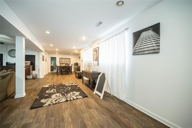 interior space featuring baseboards, dark wood-type flooring, visible vents, and recessed lighting