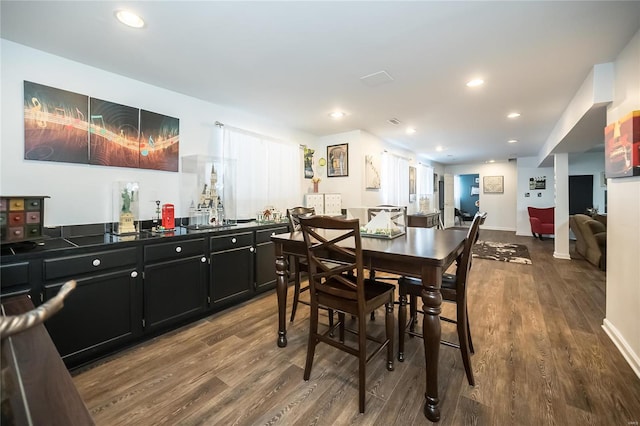 dining area featuring baseboards, wood finished floors, and recessed lighting