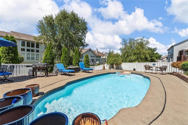 view of swimming pool featuring a patio, area for grilling, fence, and a fenced in pool