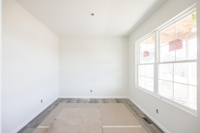 empty room with visible vents, baseboards, and wood finished floors