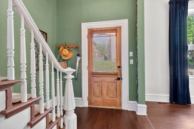 entrance foyer with baseboards, visible vents, stairs, and dark wood-type flooring