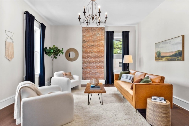 living room featuring baseboards, an inviting chandelier, and wood finished floors
