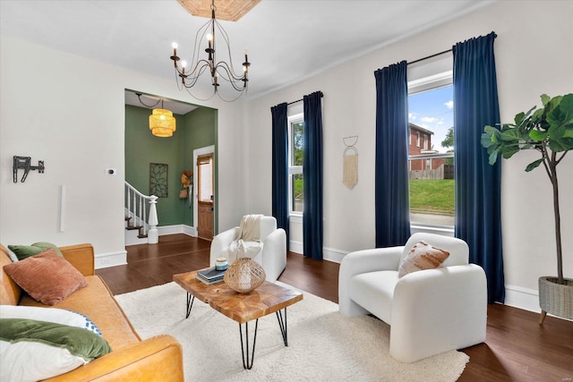 living area with stairway, a chandelier, wood finished floors, and a healthy amount of sunlight