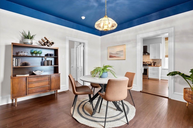 dining space featuring dark wood-style flooring and a chandelier
