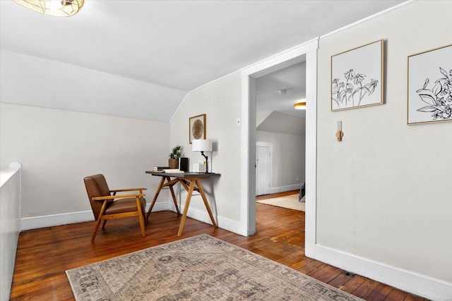 living area with baseboards, hardwood / wood-style floors, and lofted ceiling