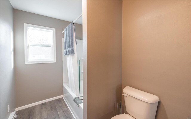 bathroom with toilet, shower / bath combo, baseboards, and wood finished floors