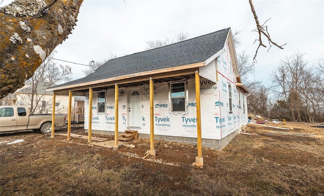 property in mid-construction with a shingled roof and a porch