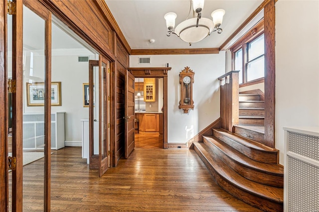 entrance foyer with visible vents, stairs, ornamental molding, and dark wood-type flooring