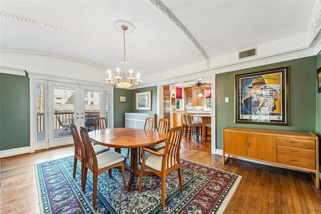 dining space featuring visible vents, baseboards, vaulted ceiling, french doors, and wood-type flooring