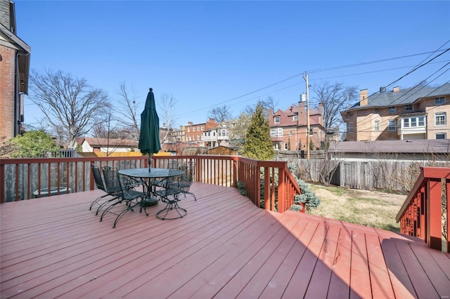 wooden terrace featuring a residential view and outdoor dining area