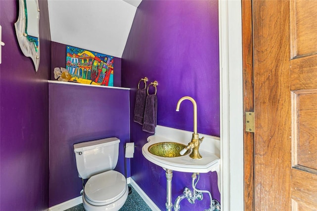 bathroom with toilet, baseboards, and a sink