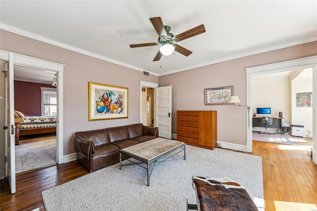 living area featuring wood-type flooring, visible vents, ceiling fan, and ornamental molding