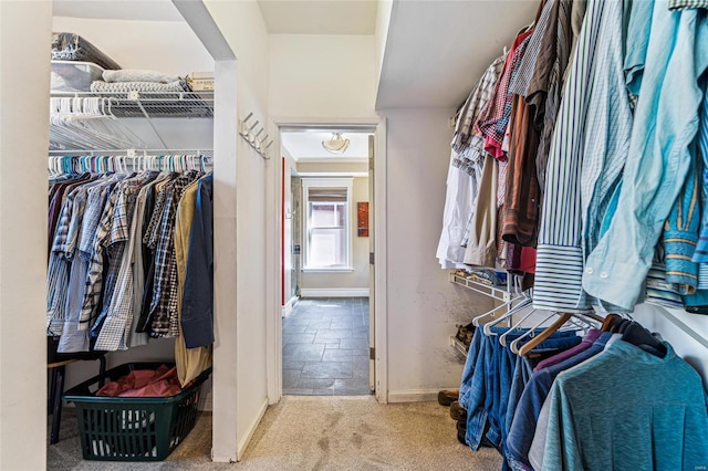 spacious closet with stone finish flooring and carpet