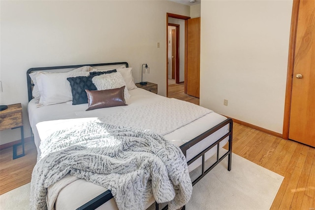 bedroom with baseboards and light wood finished floors